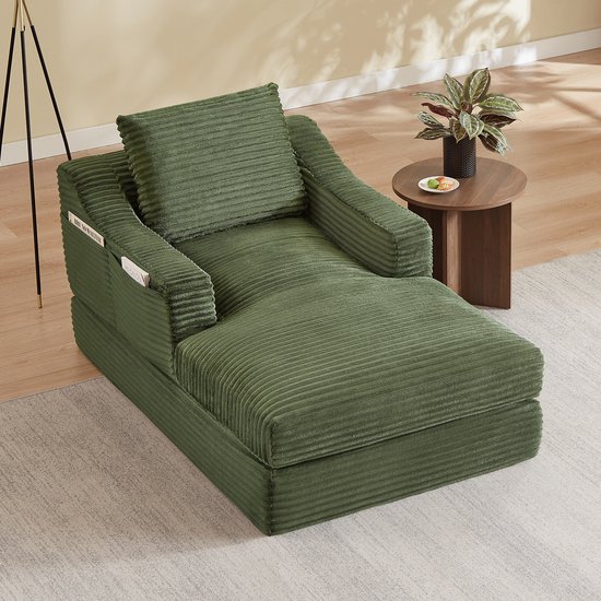 Groene corduroy fauteuil met uitklapbaar bed, in een woonkamer.