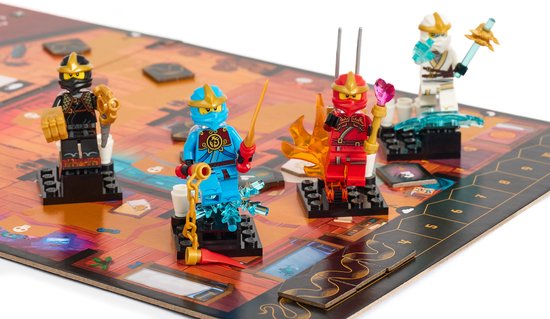 Vier LEGO NINJAGO actiefiguren op een speelbord met gouden, blauwe, rode en witte ninja's.