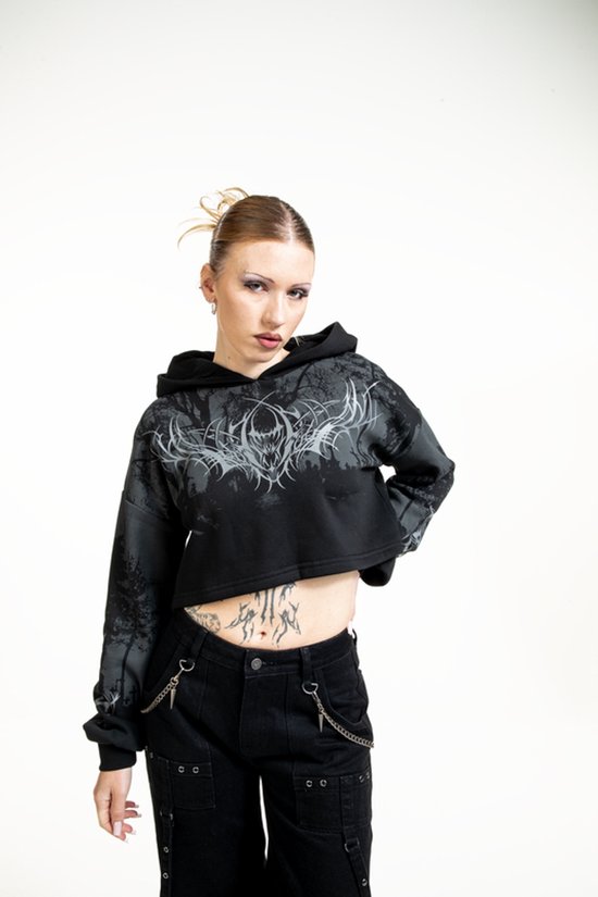 Zwarte crop hoodie met grafische print van een bos en demonische kop. Model draagt de hoodie.
