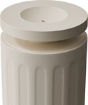 Bovenaanzicht van de beige diffuserkop met een ronde, holle bovenkant en een klein gat in het midden.