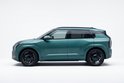 Zijprofiel van een teal Kia EV SUV met zwarte velgen.