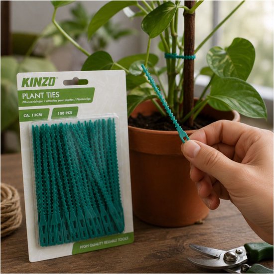 Kinzo plantenbinder, ca. 13 cm in groen, vastgehouden door een hand naast een plant.