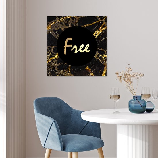 Affiche marbre noir, accents dorés et texte "Free". Accroché au-dessus d'une chaise à une table.