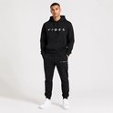 Man in een zwarte hoodie met 'VIBES' print en bijpassende joggingbroek.