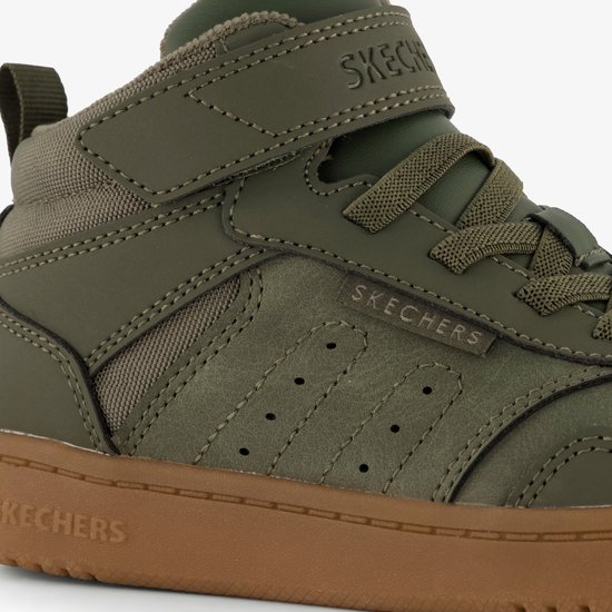 Close-up van groene Skechers mid-top sneakers. Details van de veters, klittenband en perforaties.