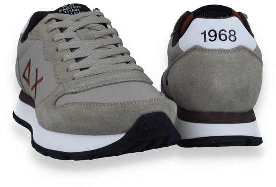 Achterkant en zijkant van beige sneakers met witte zolen. '1968' is zichtbaar op de hiel.