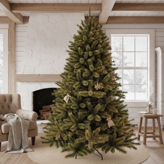 Een groene kunstkerstboom met kerstverlichting en kleine decoraties in een gezellige woonkamer.