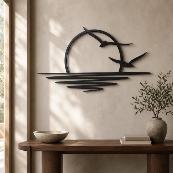 Décoration murale en métal noir d'un soleil couchant avec deux oiseaux en vol au-dessus des vagues.