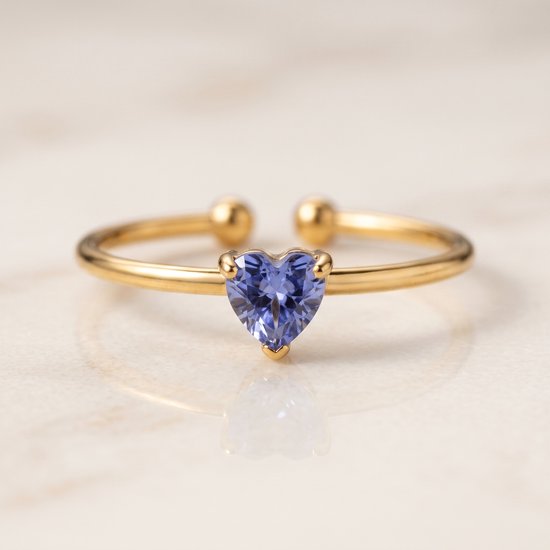 Gouden ring met een blauwe hartvormige steen.