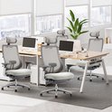 Verschillende lichtgrijze ergonomische bureaustoelen met verstelbare hoofdsteunen in een open kantoorruimte.