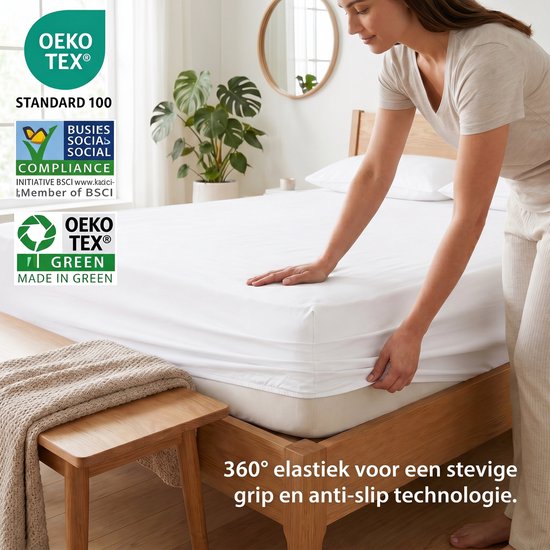 Een vrouw trekt een wit hoeslaken met OEKO-TEX certificering strak over een bed. Tekst: 360° elastiek voor een stevige grip en anti-slip technologie.