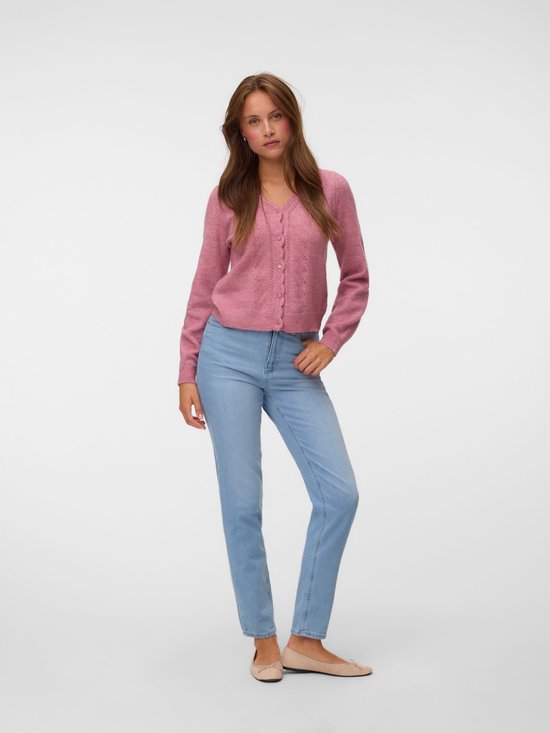 Model in lichtblauwe mom fit jeans en een roze vest, gedragen met ballerina's.