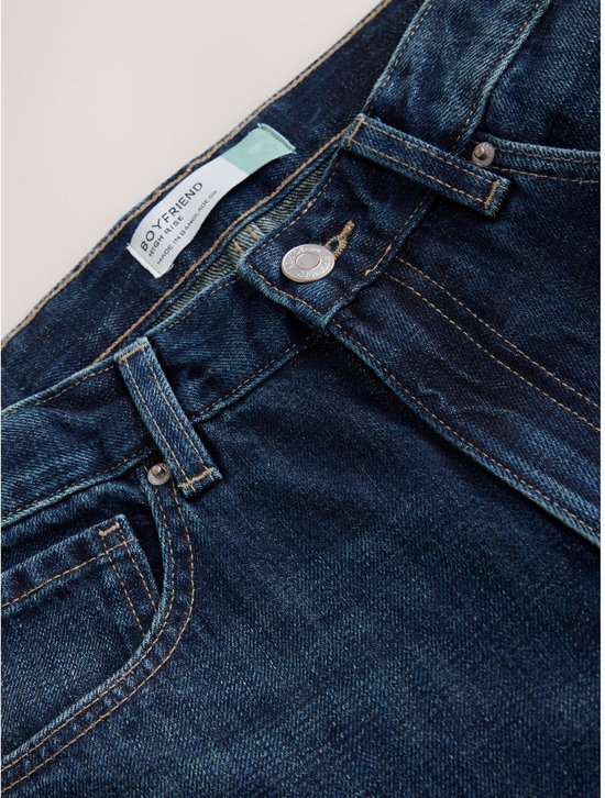 Donkerblauwe boyfriend jeans, met een label met 'BOYFRIEND' erop.