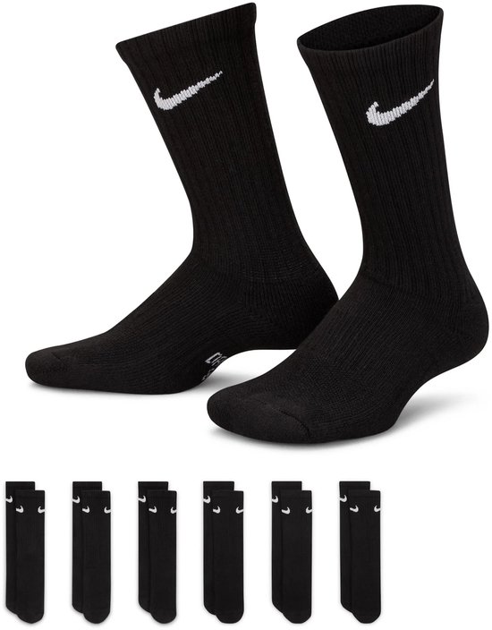 Deux chaussettes Nike noires portées aux pieds, avec logos Nike blancs. Six paires de petites chaussettes en bas.