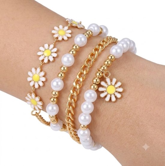 Trois bracelets dorés avec perles, marguerites et maillons au poignet.