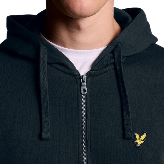 Man met donkerblauwe hoodie, rits op de borst met geel adelaarslogo.
