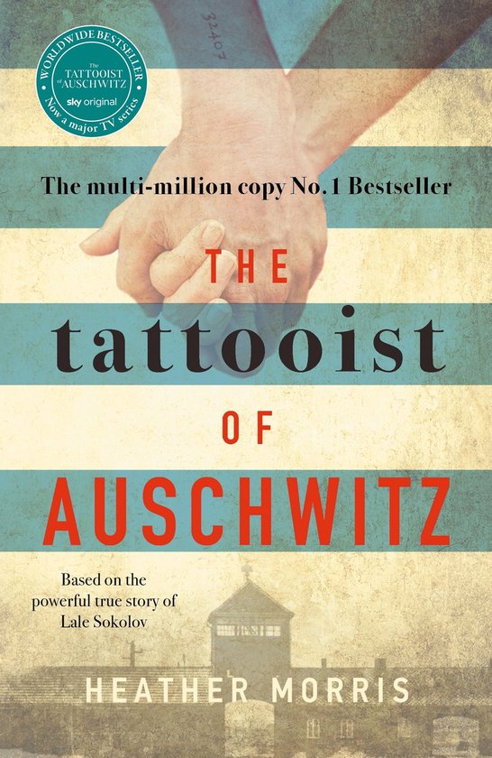 Boekomslag van 'The Tattooist of Auschwitz' met gestileerde handen die elkaar vasthouden. Titel in grote letters.