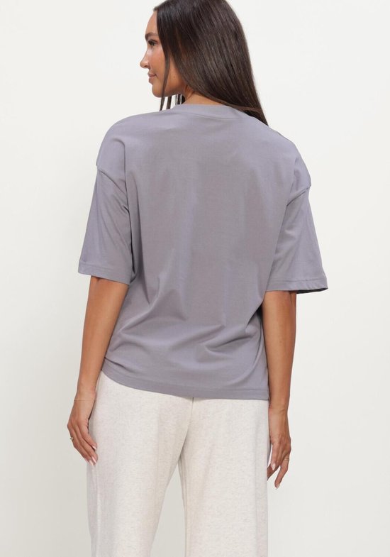 Achterkant van een grijze New Balance Athletics oversized T-shirt gedragen door een model.