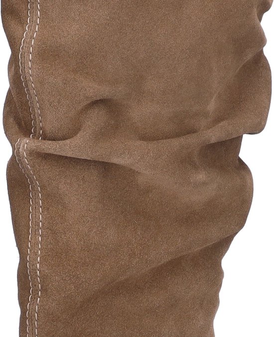 Close-up van de beige suède schacht met een geplooide textuur en opvallende stiksels.