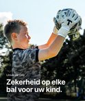Jongen met witte keepershandschoenen die een voetbal omhoog houdt.
