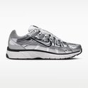Grijze Nike P-6000 sneaker met metallic zilveren overlays, witte veters en een zwarte zool.