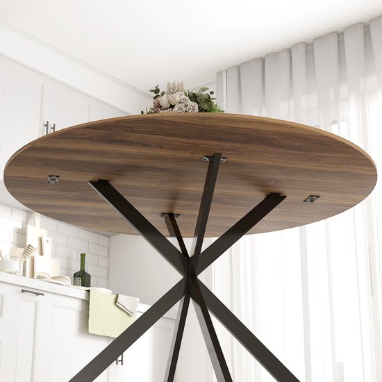 Onderkant van een ronde houten eettafel met een zwart X-vormig metalen onderstel.