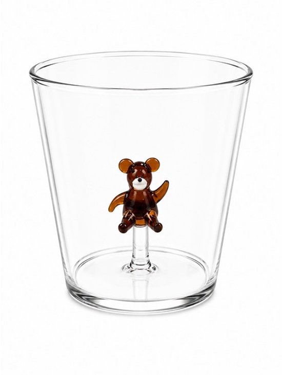 Un verre transparent avec un petit ours en peluche en verre brun sur le fond.