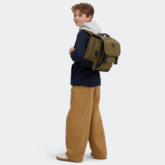 Jongen met een groene Kipling rugzak met donkerblauwe details en een harige aap sleutelhanger.