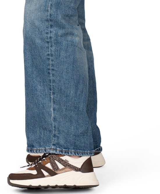 Dames met blauwe wijde jeans en bruine sneakers met luipaardprint en witte mesh.