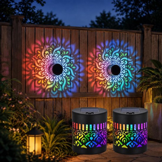 Twee zwarte, zonne-aangedreven tuinlampen die kleurrijke mandala-projecties weergeven op een houten schutting.