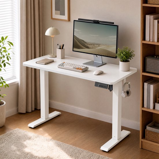 Wit elektrisch verstelbaar bureau met computer, toetsenbord, muis, koptelefoon en plant.