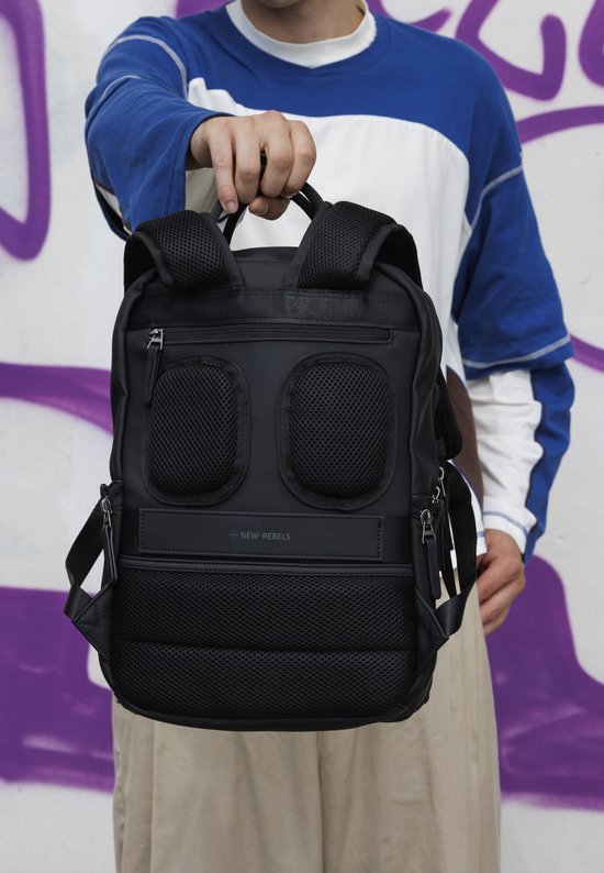 Zwarte New Rebels rugzak met mesh vakken en laptopvak voor 15,6 inch. Een man met een blauw-witte trui draagt de rugzak.