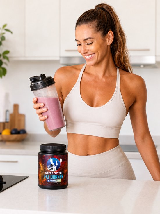 Vrouw met sportkleding houdt een roze smoothie vast naast een pot "Sterrenstof Fat Burner Blueberry Lemon" in een keuken.