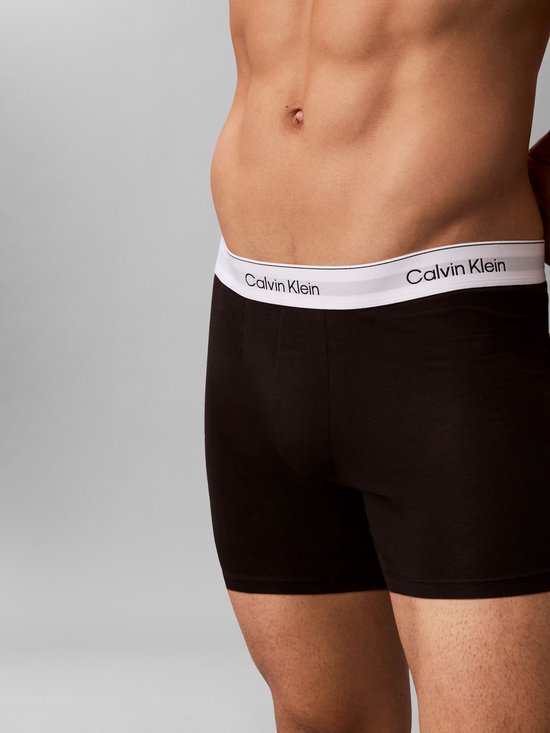 Close-up van donkere Calvin Klein boxer briefs met witte tailleband met logo.