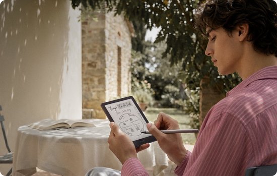 Jonge man in roze gestreept shirt gebruikt een BOOX Go 6 (Gen II) e-reader in een tuin.