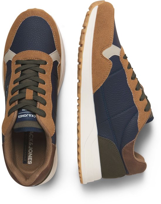 Zijaanzicht van een paar donkerblauwe sneakers met suède bruine, beige en groene panelen. Groene veters.