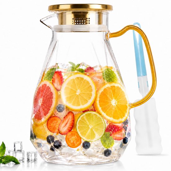 Carafe à anse dorée en verre remplie de divers fruits tels que fraises, myrtilles, orange, citron et pamplemousse.