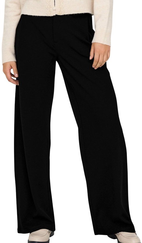 Gros plan avant d'un cardigan beige et d'un pantalon large noir.