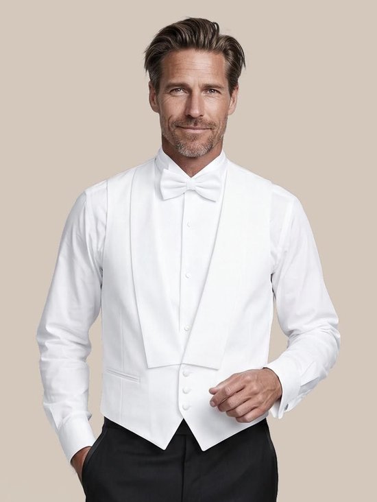 Man in wit smokinghemd, wit jacquetvest en zwarte broek.