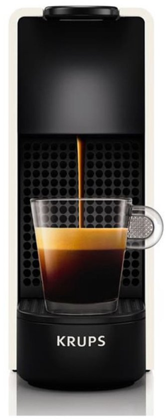 Krups Nespresso Essenza Mini blanche avec accents noirs, dans laquelle de l'espresso est versé dans un verre.