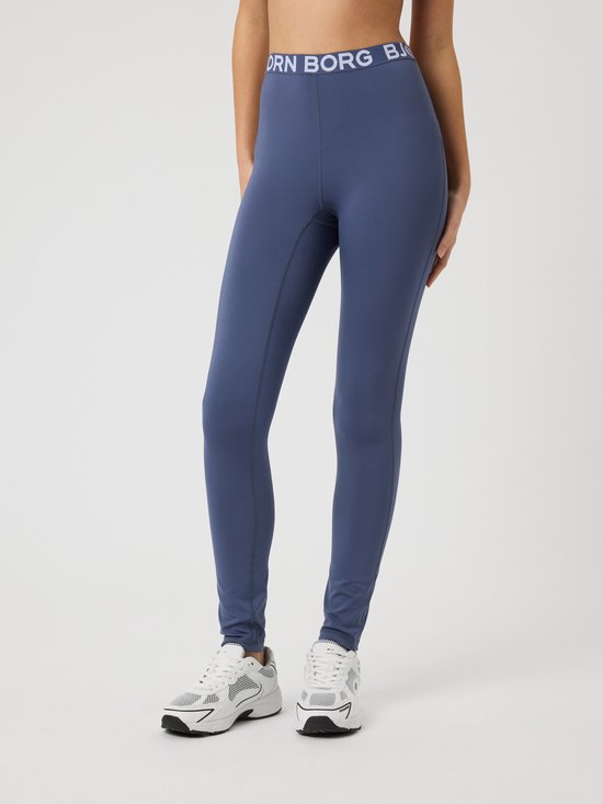 Meisje draagt een blauwe Björn Borg legging met logo tailleband en witte sneakers.