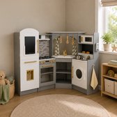 Grijze houten speelgoedkeuken met witte accenten, accessoires en een teddybeer ernaast.