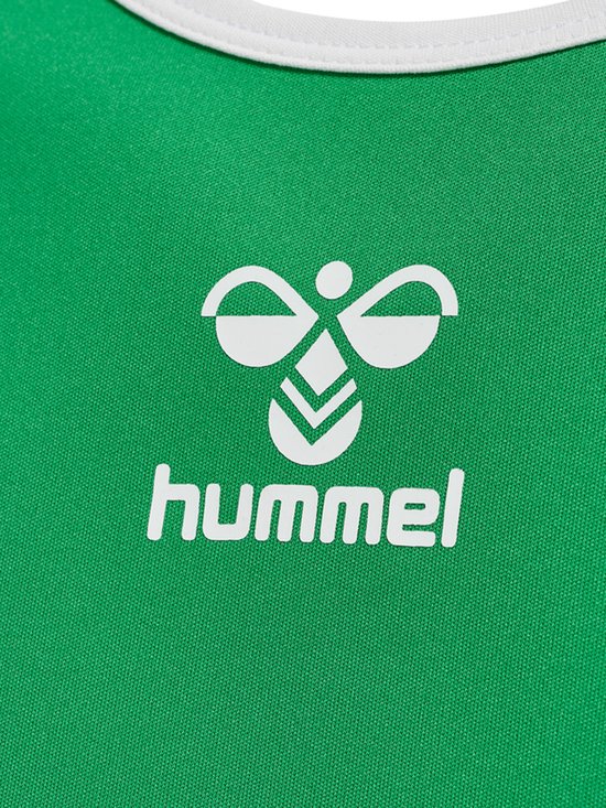 Detail van de groene sporttop met het witte hummel-logo en bijpassende chevron-details.