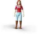 Jong meisje met rood shirt, blauwe broek en bruine laarzen, met rood haar.