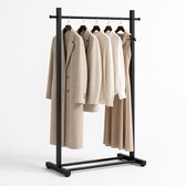 Zwart kledingrek met beige jas, crèmekleurige trui, beige blouse en beige jurk.