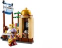 Een LEGO-figuur met een paarse hoed en een rode outfit, met een goudkleurige telescoop, staat voor een piratenschip met vlaggen.