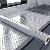 Zilveren aluminiumfolie met ruitpatroon op aanrecht en rondom de gootsteen, met een rol folie.