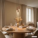 Drie koperkleurige hanglampen met geribbelde structuur hangend boven een eettafel.