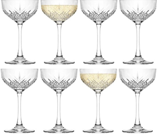 Huit verres à champagne coupe en cristal, dont deux remplis de champagne.