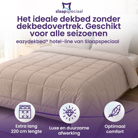 Een beige dekbed met ruitpatroon op een bed. Iconen voor extra lang, luxe en optimaal comfort. Tekst: 'Het ideale dekbed zonder dekbedovertrek. Geschikt voor alle seizoenen', 'Extra lang 220 cm lengte', 'Luxe en duurzame afwerking', 'Optimaal comfort'.